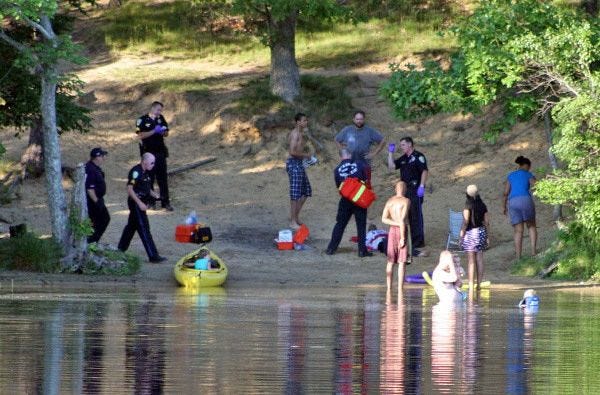 Sandwich police and fire department personnel attend to a swimmer who had to be rescued in Hoxie Pond yesterday.