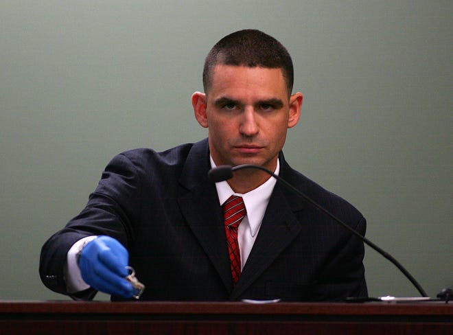 State Police chemist John Soares holds up a set of house keys while being questioned during the murder trial of Neil Entwistle at Middlesex Superior Court on Friday. Entwistle, a British citizen, is charged with first-degree murder in the death of his wife, Rachel, and infant daughter, Lillian, in their Hopkinton home in January 2006.