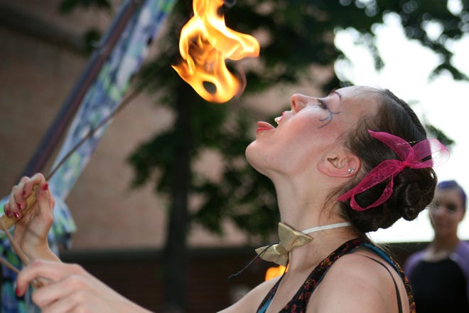 M.A. “Mimi” Harrison of Kalamazoo’s Aerial Angels prepares to swallow fire during the kickoff to this summer’s Street Performer Series at GDK Park in Holland.