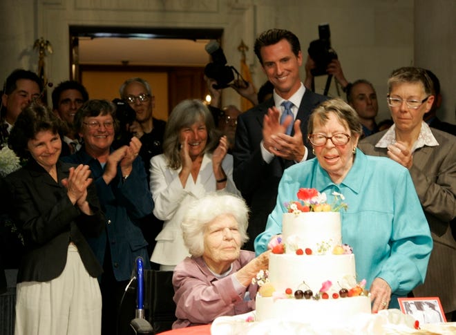 Del Martin, left, and Phyllis Lyon, right, cut their wedding cake after being married by San Francisco Mayor Gavin Newsom, standing behind them, at City Hall in San Francisco on Monday.