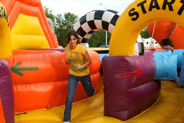 EJ Hersom/Staff Photographer
Ali Barry, 11, of Somersworth crosses the finish line of an inflatable relay race attraction during the Somersworth International Children's Festival Friday evening.
