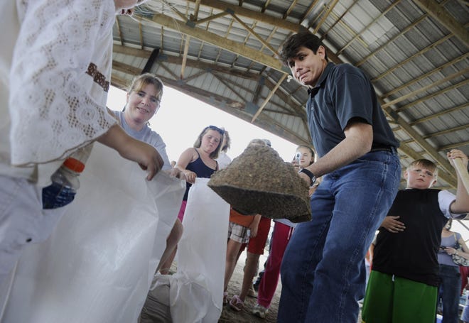 Gov. Rod Blagojevich fills a sandbag Friday at the Pike County Fairgrounds in Pleasant Hill on a tour of flood-ravaged areas.