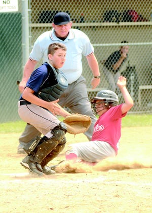 Brandon Daniels of the Phillies, right, scores before Falcons catcher Taylor Mackey gets the throw during Saturday’s little league game in Massillon.