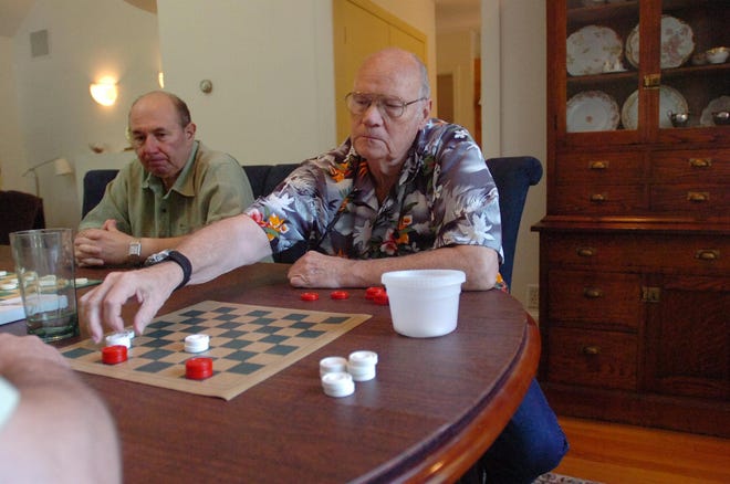 Wally Galvin, of Andover, makes a move during his checker game against Steve Kelly, of Medford on Saturday, June 21 at Richard White's Dover home. Looking on next to Galvin is Mike Magnelli, last year's winner of the New England Checker Federation Tournamnent.