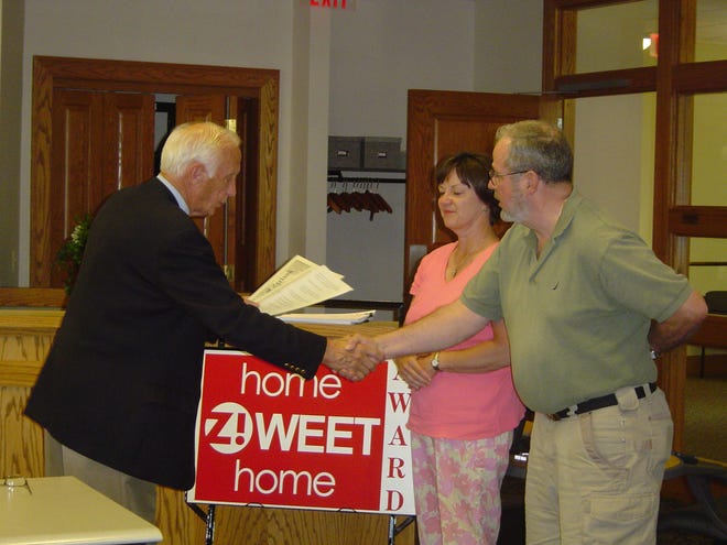 Zeeland Mayor Les Hoogland presents the Home Zweet Home Award Monday, June 23, to Ray and Debbie Kirn. They own 117 S. Church St.