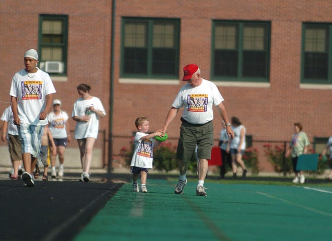 Cancer survivor David "Doc" Holliday, center, of North Stonington, walks with his grandson, Garrett Holyfield, 2, of Gales Ferry, during a Relay for Life event at Norwich Free Academy Saturday, June 28, 2008.