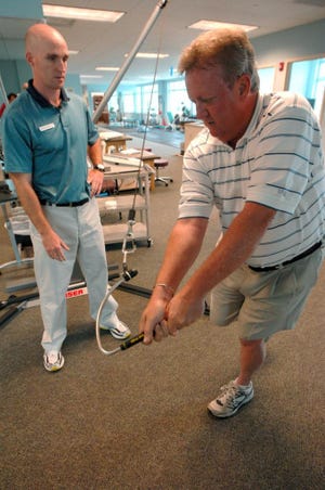 Physical therapist Jason Hux works with golfer Clint Land on Tuesday at Chatham Sports Medicine and Physical Therapy. Richard Burkhart/Savannah Morning News