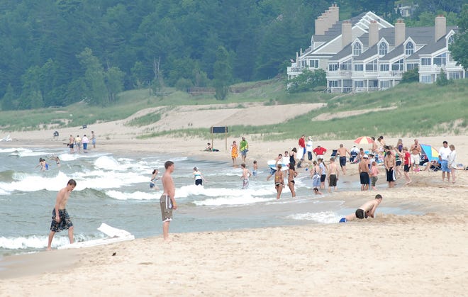 Visitors swim in Lake Michigan at Holland State Park Thursday. On July 13, 1938, a sudden seiche swept people off breakwaters and boats, resulting in five fatalities.