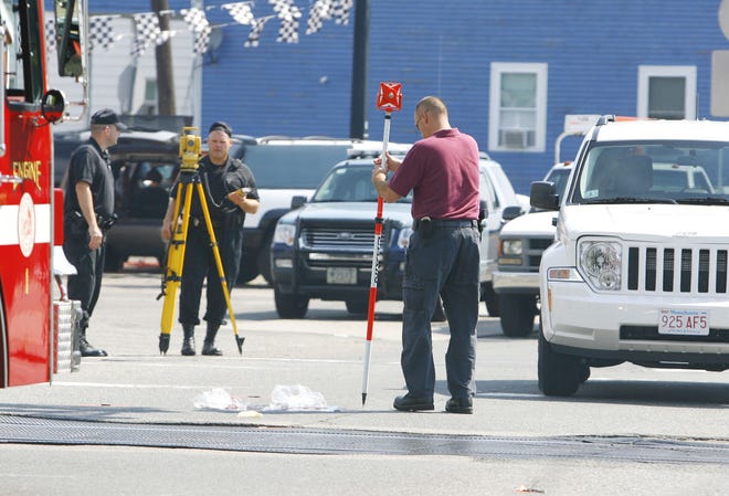 A State police investigator checks the tire pressure of a white Jeep SUV that struck and killed a Whitman man as he crossed the road at South Street near the MBTA commuter rail tracks in Whitman.