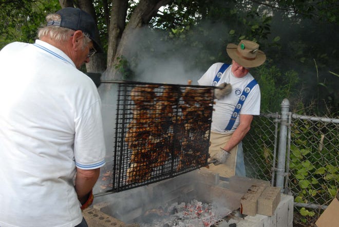 Danielson Elk members Jim Murray left and Will Blain flip the chic ken over on the barbecue during the Red, White and Blue Barbecue at Owen Bell Park.