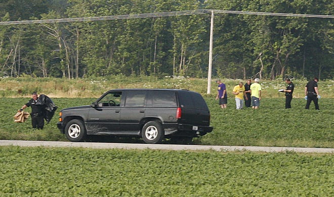 Emergency personnel investigate the scene Friday of a Glenarm skydiver’s death near Taylorville Municipal Airport. An autopsy has been scheduled for today at Memorial Medical Center.