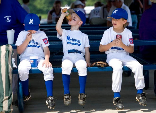 Northport Nationals players Jackson Shipp, left, Cason Burroughs, and Holden Morris, all 6, take a break in between games at the Dizzy Dean Youth Baseball Tournament at Kentuck Park in Northport on Friday. The tournament featured teams from 3-states.