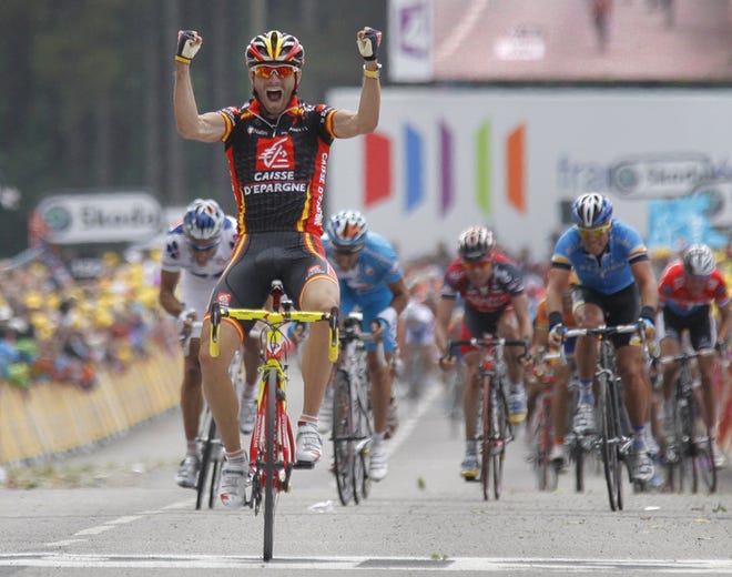 Alejandro Valverde, of Spain, raises his arms as he crosses the finish line to win the first stage and capture the yellow jersey.