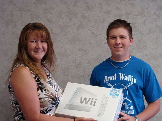 Happy as a lark: TimesNewspapers circulation manager Julie Howell hands Chillicothe Times-Bulletin carrier Matt Welch the Nintendo Wii he won through a recent subscription contest.