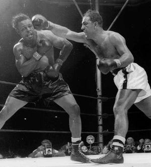 World heavyweight champion Rocky Marciano delivers a right, that was followed by a left, that sent challenger Archie Moore to the canvas for the full count in the ninth round of their 15-round title bout, Sept. 21, 1955, at Yankee Stadium in New York.
