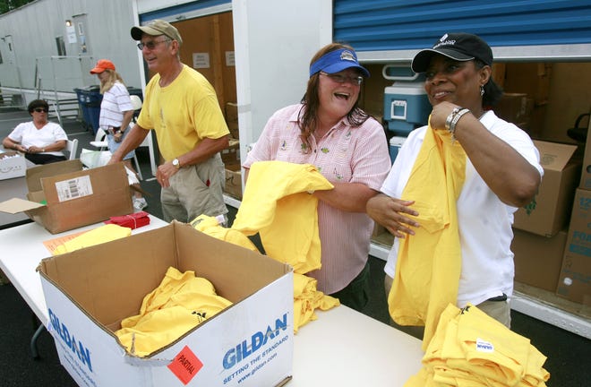 State Farm Classic volunteers, from left, Mike Burke of Springfield, Teresa Sons of Girard and Cindy White of Springfield organize and T-shirts to be distributed to others who will be helping with the tournament.