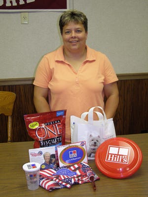Cambridge Main Street director Sheryl King shows one of the doggy goodie bags residents will receive if they enter their dog in the ‘Just for Fun Dog Show’ Saturday, Aug. 16, during the Sixth Annual Cambridge Main Street Family Fest and Auto Show. The dog show is one of several new activities scheduled for this year’s show.