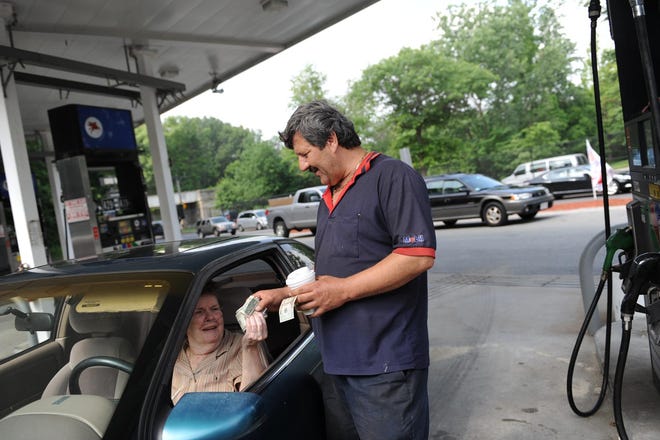 Nick Azar, manager of Parkway Mobil in West Roxbury, pumps gas for Loretta Campbell. Azar says they are staying afloat because of regular customers like Campbell, who drives from Roslindale just to go their station.