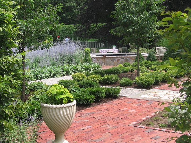 A view of landscape designer Christina Button’s garden at her 32 Main St. home in Mattapoisett demonstrates Button’s eye toward texture. “As a landscape designer, I use my garden as a sort of field station for practicing horticulture and growing a variety of species to learn their habits before recommending them to clients,” Button, a landscape designer for Bartlett Gardens, said. “The emphasis here is on low maintenance” primarily trees and scrubs and massing of several perennial species in spaces defined by hedges and paths. We have gathering spots around tables and fire, as well as private places for calm and rejuvenation.”