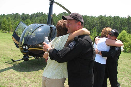 The bird lands 
New Hanover County Sheriff's Lt. Scott Gerow hugs Toni Shields, the office's business manager, while Brooke Hudson, adminstrative support technician, embraces Dep. Charles Smith, a tactical flight officer. Smith and Gerow went to Houston to pick up the new helicopter.
