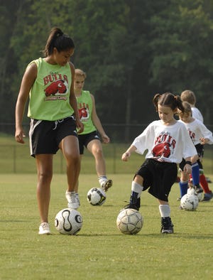 Nina Morales, 16 (left), helps Shanleigh Wahl, 7, at soccer camp. The GA-SC Bulls Soccer Camp in North Augusta is in the second of three weeks. More than 80 kids have participated each week.