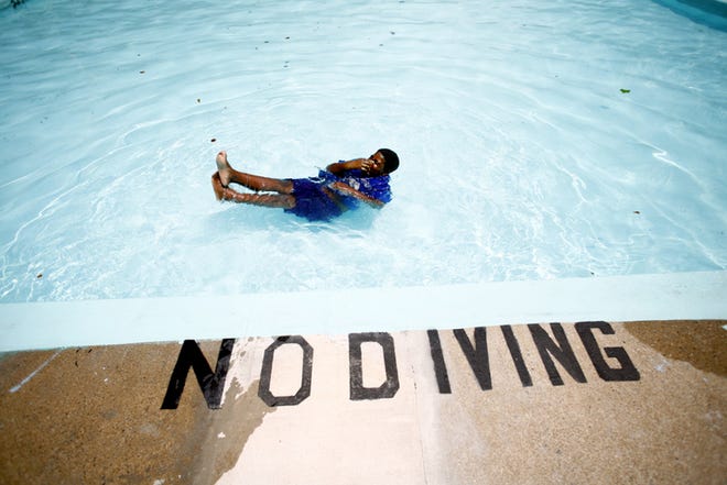 Josha Mormant, 10, does a "twist," a trick where he spins around in the water, in the May Park pool in Augusta. Richmond County pools will close next week; the last day to swim will be Friday, Aug. 1.