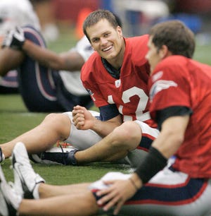 Patriots quarterbacks Tom Brady, center, and Matt Cassel, right, talk while stretching during Thursday's opening day of team training camp in Foxboro.
