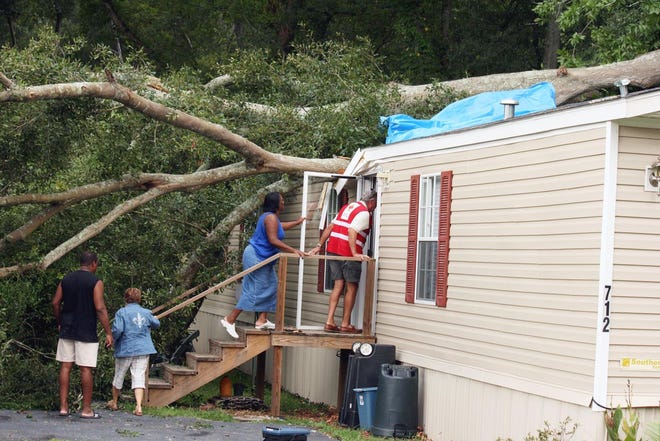 From left, Reginald Roberts, Red Cross representative Natalie Johnson, Joyce C. Scott and Red Cross representative Gene Gonzales, prepare to inspect the trailer rented by Roberts and Scott at 712 Gautreau in Gonzales. The tree beside the trailer split around 3 a.m. Thursday and fell on the trailer while Roberts and Scott were in the home. Staff Photo by Wade McIntyre