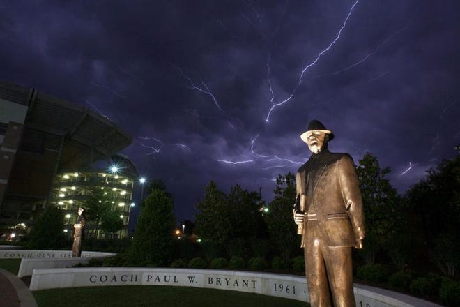 Lightning streaks across the sky above a statue of Paul W. Bryant near Bryant-Denny Stadium as storms moved through the area Saturday night.