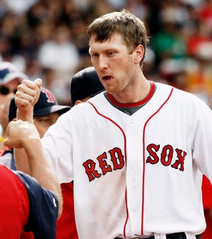 Jason Bay is congratulated by his Red Sox teammates after scoring in the sixth inning Sunday.