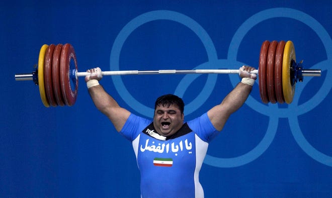 Iranian Olympic gold medallist Hossein Rezazadeh competes during the Olympic Games in Athens in this 2004 file photo. Rezazadeh will not compete in Beijing because of a knee injury, an Iranian news agency reported July 30.