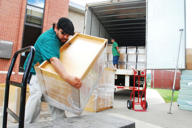 Stuart Deane, maintenance employee of Dorm Corp., loads a dresser onto a moving cart Monday Aug. 4, 2008, after receiving a load of dressers and wardrobe closets from the tractor-trailer outside of the John Butterfield Residence Hall at Mohawk Valley Community College in Utica.