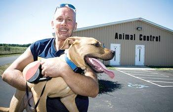 Joe Poloski hugs his newly adopted dog at the St. Joseph County Animal Shelter on Saturday. “I'm not sure,” said Poloski, “I think I may name him Spaz because he's so excited to be friends with me.”