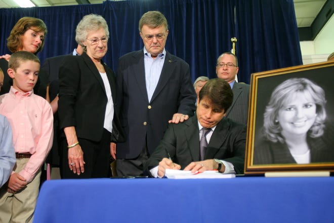 Illinois Gov. Rod Blagojevich, with Bischof family members behind him, signs the Cindy Bischof law on domestic violence, at Hull House Uptown Center on August 4, 2008, in Chicago.