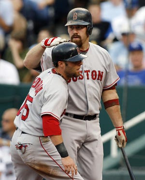 Kevin Youkilis (rear) pats Dustin Pedroia on the head after Pedroia scored during the Red Sox' win over the Royals.