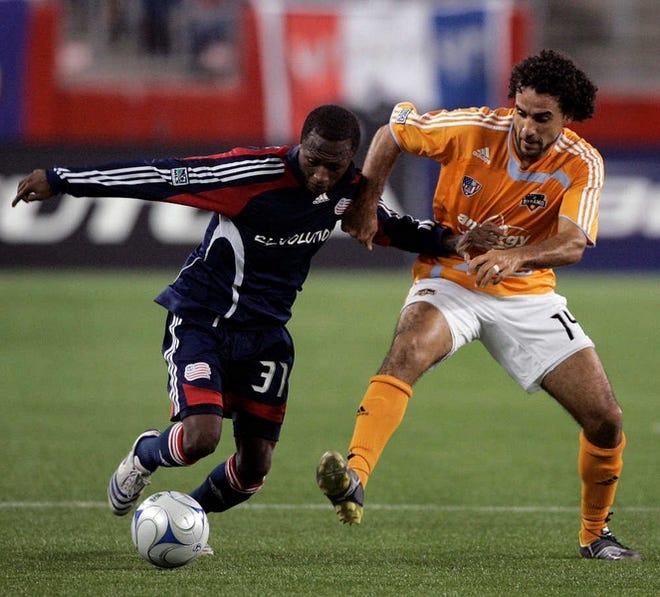 The Revs’ Sainey Nyassi, left, battles with Houston’s Dwayne De Rosario for control of the ball.