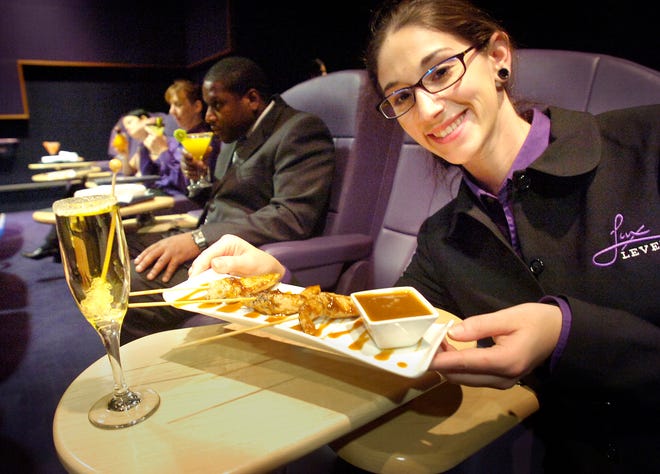 National Amusements' new Showcase Cinema, a luxury movie theater, will open next week in Patriot Place in Foxboro, where Courtney Martel serves food and drink to patrons at their seats.