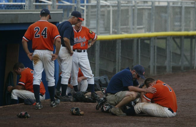 Smith Post’s Zack Ciccotti (7) is comforted by his uncle and team trainer, Bobby Ciccotti, on Sunday after the New York State American Legion championship at Delano-Hitch Stadium in Newburgh. Anaconda won 9-8 in 11 innings.