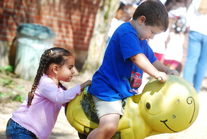 Gabriela Mateo, 4, left, pushes Christopher Iannone, 4, on a ride Tuesday, Aug. 12, 2008, on the playground at the Neighborhood Center on Mary Street in Utica.