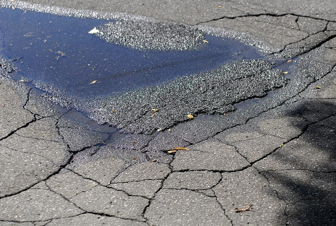 Potholes and cracked pavement on Ferndale Place in Utica.