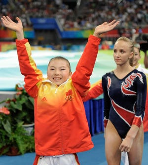 China's He Kexin, left, waves to the crowd. He won the gold, while U.S. gymnast Nastia Liukin, right, took the silver medal in the uneven bars finals Monday at the Beijing 2008 Olympics. Both women had the same scores. (AP Photo/Matt Dunham)