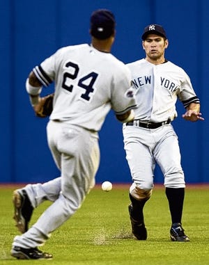 New York Yankees' Johnny Damon, right, and Robinson Cano (24) chase down a shallow hit by Toronto Blue Jays Joe Inglett during third-inning AL action in Toronto on Thursday, Aug. 21, 2008. (AP Photo/The Canadian Press,Frank Gunn)