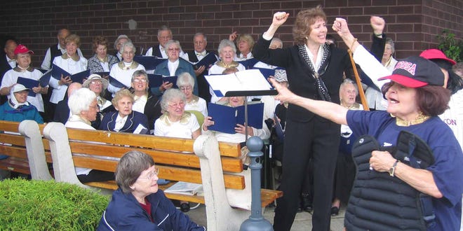 Get a taste of good music and barbecue when the Golden Tones chorus kicks off its 21st season with a free concert Saturday, Aug. 30, at 12:30 p.m., outside the Natick Stop & Shop, corner of routes 9 and 27, in Natick. Hot dogs and hamburgers will be available from 11:30 a.m. to 4 p.m. Proceeds from the barbecue will benefit the Golden Tones' musical outreach to underserved audiences in our community. Above, acting director Deborah Marion Foner and dancer Carole Felz lead a singalong at a recent Stop & Shop barbecue concert, enjoyed by Barbara Procum of Natick.