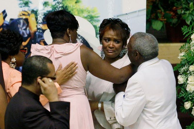 Rhonda McCullough, second from the right, wife of comedian Bernie Mac, is comforted at a memorial service celebrating the life of her late husband.