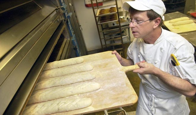 Baker Sam Harris, who owns Harris Baking Co. in Drayton Tower, loads uncooked bread into an oven. (Carl Elmore/Savannah Morning News)