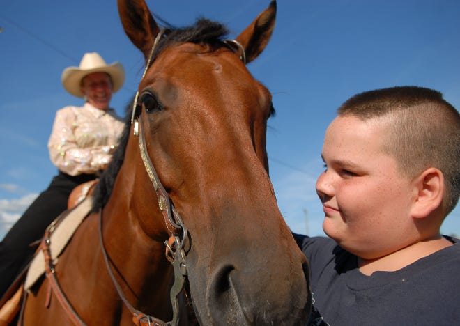 Austin Stone, 12, of Brooklyn, right, pets his horse "Chex" after his mother, Karen Stone, left, rode "Chex" in the Open Western competition at the Brooklyn Fair Saturday, August 23, 2008.