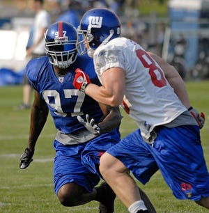 New York Giants linebacker Mathias KiwanukA, LEFT, covers tight end Kevin Boss during training camp earlier this month. Kiwanuka will play defensive end for Osi Umenyiora.