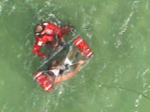 Screen grab from Coast Guard video of helicopter rescue of three in Barnstable yesterday.