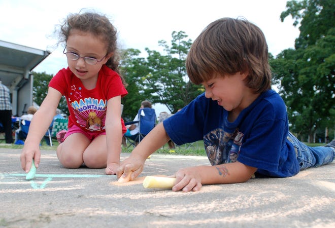 Mya Brown, 4, and Laurence Curley, 4, both of Utica, draw a picture with chalk Thursday at the Addison C. Miller Park Centennial Celebration in Utica. A 100th birthday party was held to honor the park for providing a century of good health and recreation. About 200 people came to celebrate. The event featured birthday cake, speeches, treats and jazz. “I was a lifeguard here in the 1950s, and this park is important to me. It beautifies the area,” Virginia Malecki of West Utica said.