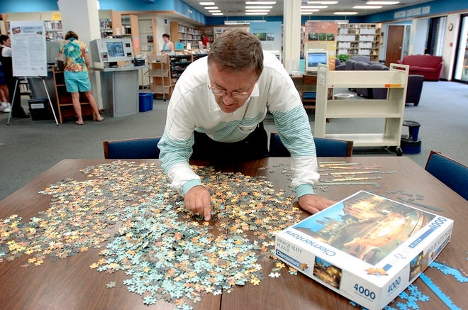 Glenn Boston of Sarasota works on a 4,000-piece puzzle of Rome's Piazza di Spagna, or the Spanish Steps, at the Gulf Gate Library on Aug. 15. A new 
approach to library services in Sarasota County means a shift in the way space is used, and the county will hold meetings to get public input.